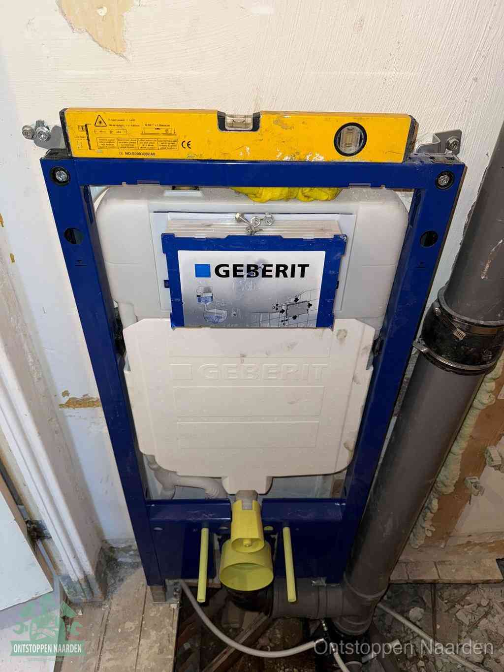 Een Geberit inbouwreservoir met frame voor een hangtoilet tegen de wand, met de afvoerbocht naar de vloer, kenmerkend voor een verstopt hangtoilet in Naarden