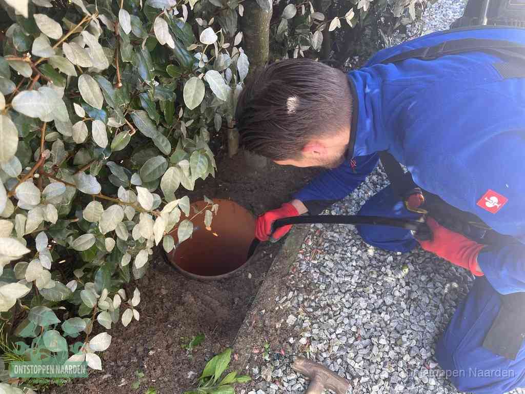 Monteur reinigt een rioolput met een slang, periodieke rioolreiniging in Naarden