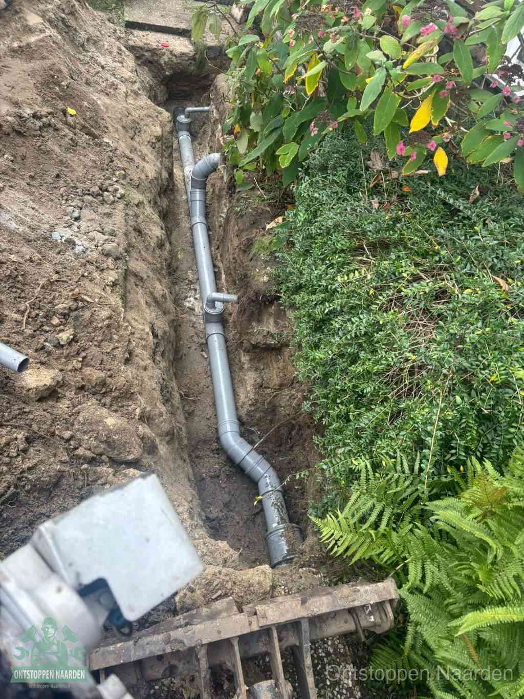 Open sleuf met nieuwe PVC-buizen, riool repareren en vervangen in Naarden