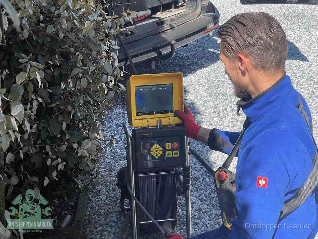 Monteur bedient een rioolinspectiecamera met monitor voor rioolinspectie in Naarden