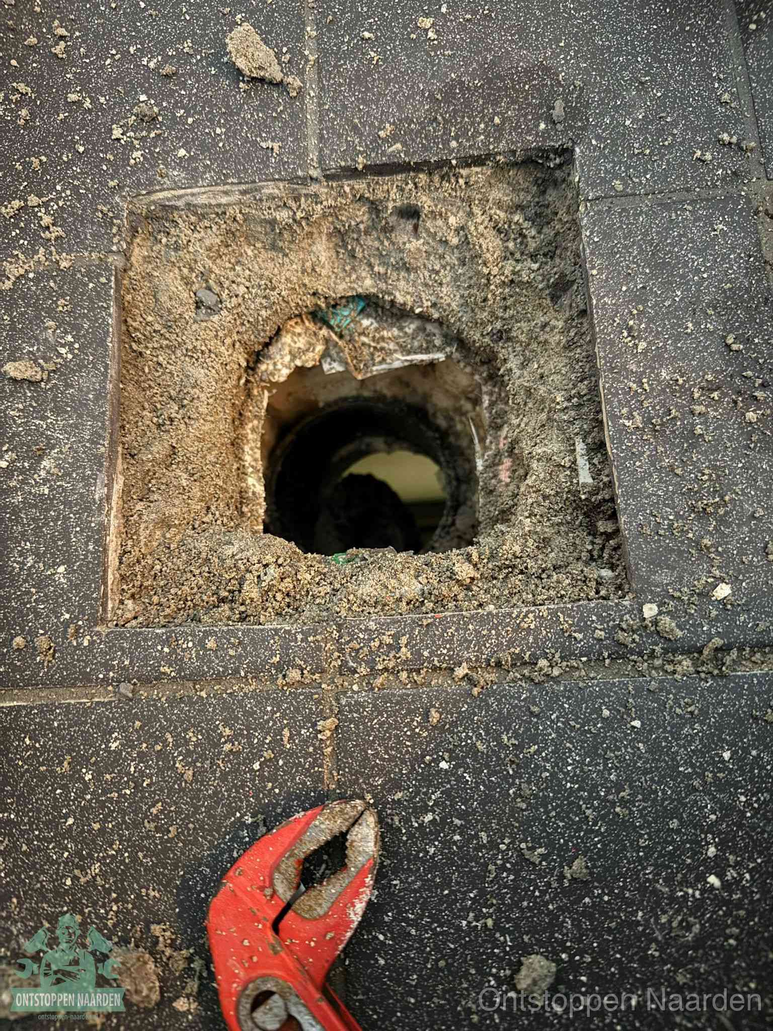 Geopend rioolputje op de erfgrens dat laat zien wie eigenaar is van de riolering in Naarden