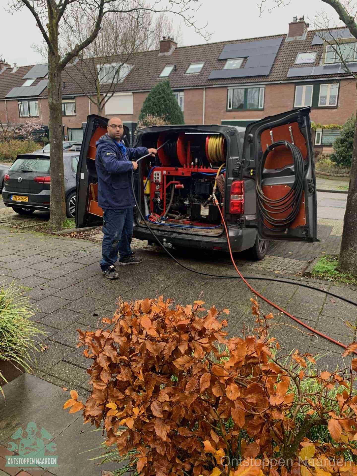 Monteur met rioolreinigingsbus levert rioolservice in de wijk in Naarden