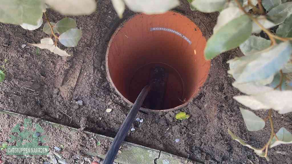 Open inspectieput in de tuin waar een veer rioolvliegjes en stankoverlast aanpakt in Naarden