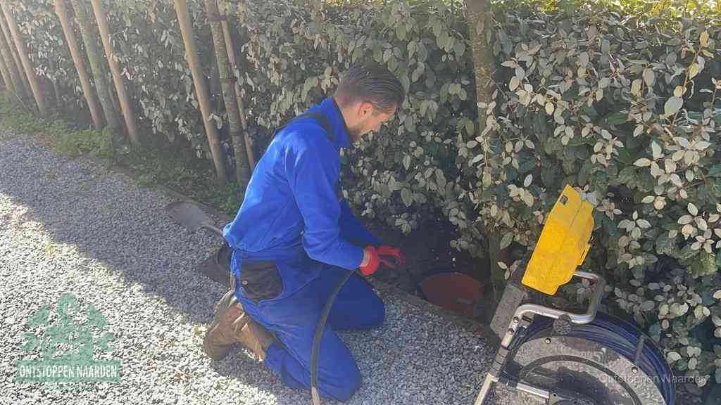 Monteur aan het werk bij een rioolput, de werkwijze voor riool ontstoppen in Naarden