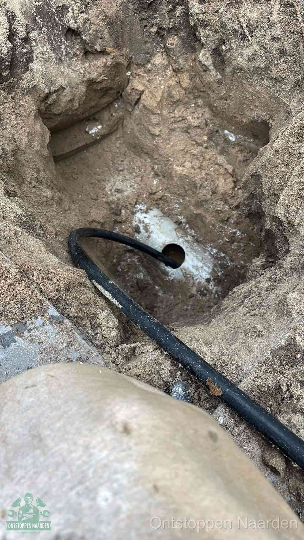 Uitgegraven rioolbuis in de grond, hulp om zelf het riool te ontstoppen in Naarden